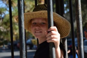 Girl in straw hat inside old-fashioned jail