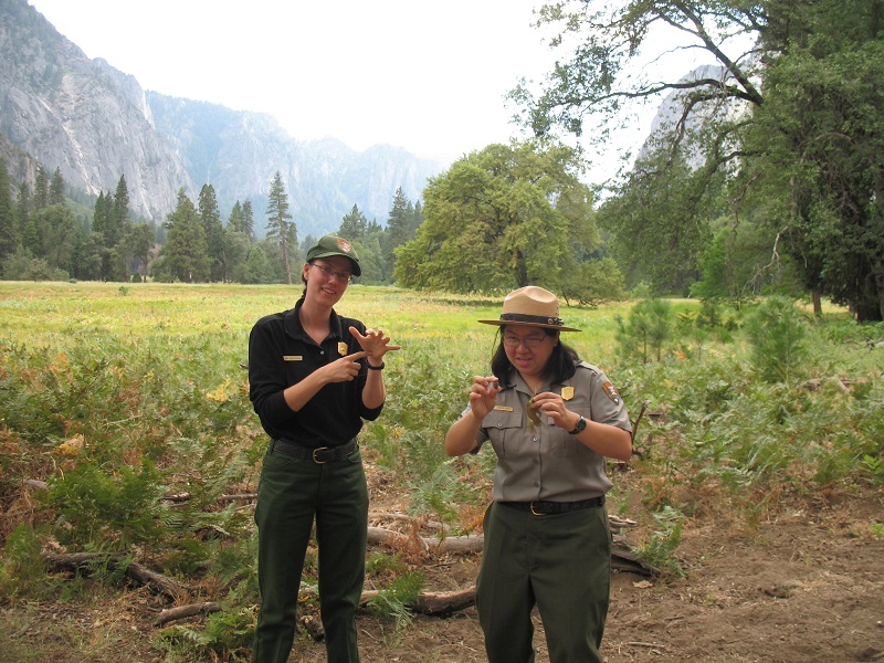 A uniformed park ranger provides American Sign Language interpretation in Yosemite National Park